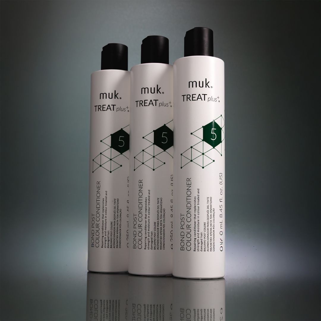 Three bottles of muk. Treat Plus conditioner on a gray background